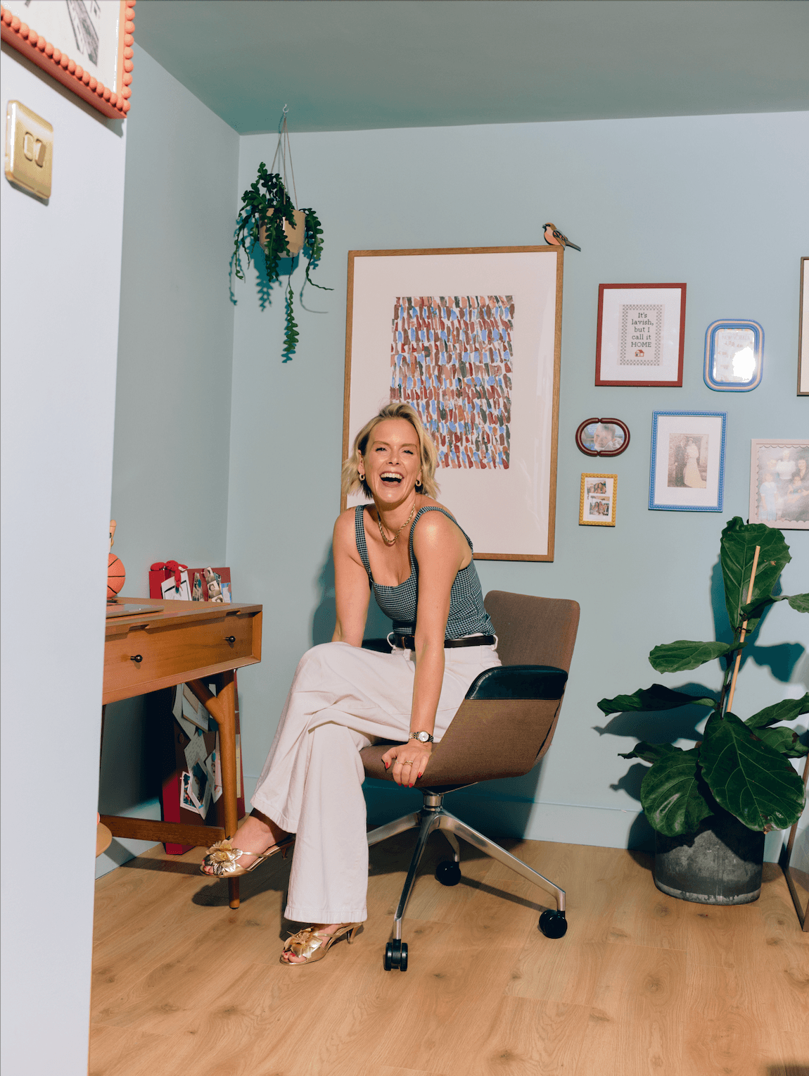 Lauren sitting on an office chair at her desk smiling